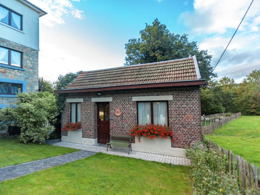 a small brick house with flowers in a yard at Holiday Home in Malmedy with terrace in Malmedy