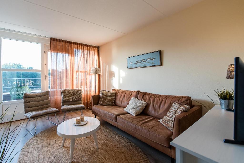 a living room with a couch and a table at Vleijenhof Type C in Buren