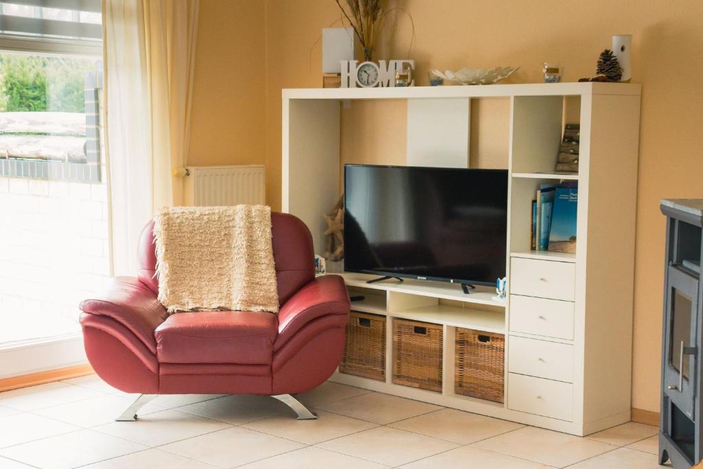 a living room with a chair and a television at Strandstr 4b "Likedeeler 2" in Zingst