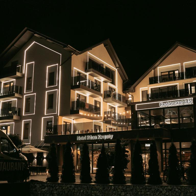 a large building with lights on it at night at Ribas Karpaty in Bukovel