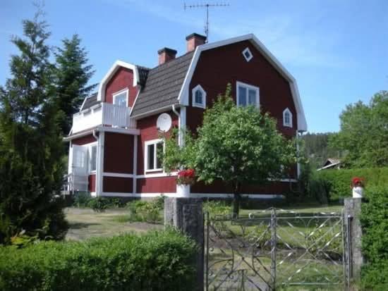 a red house with a fence in front of it at Michel-Inn-Your Scandinavian Escape! in Faggemåla