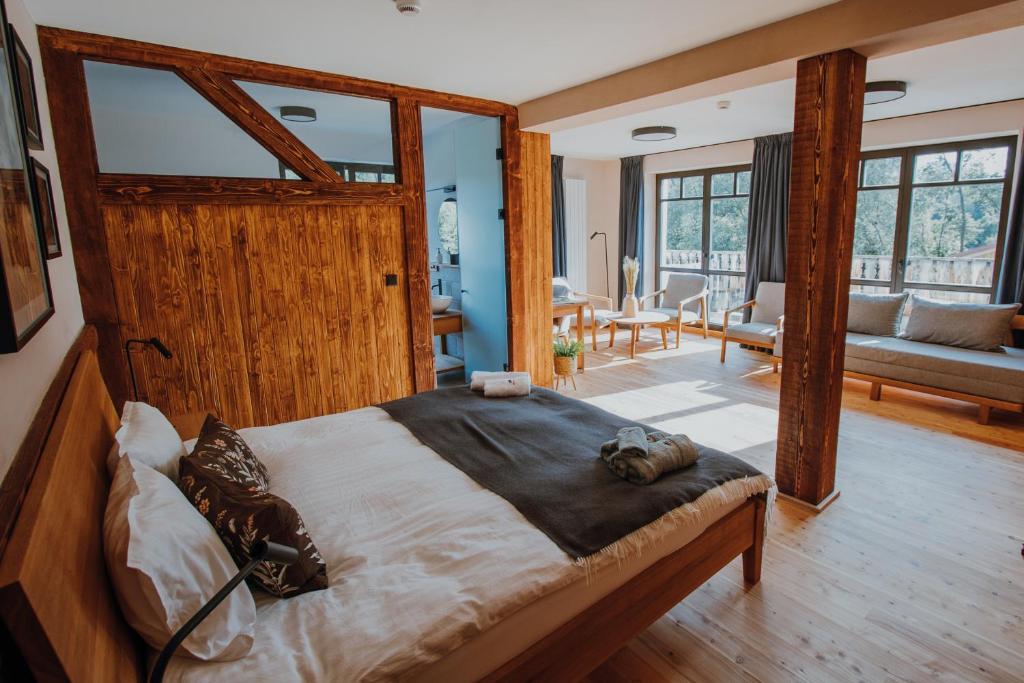 a bedroom with a large bed and a living room at Equus Silvania in Şinca Nouă