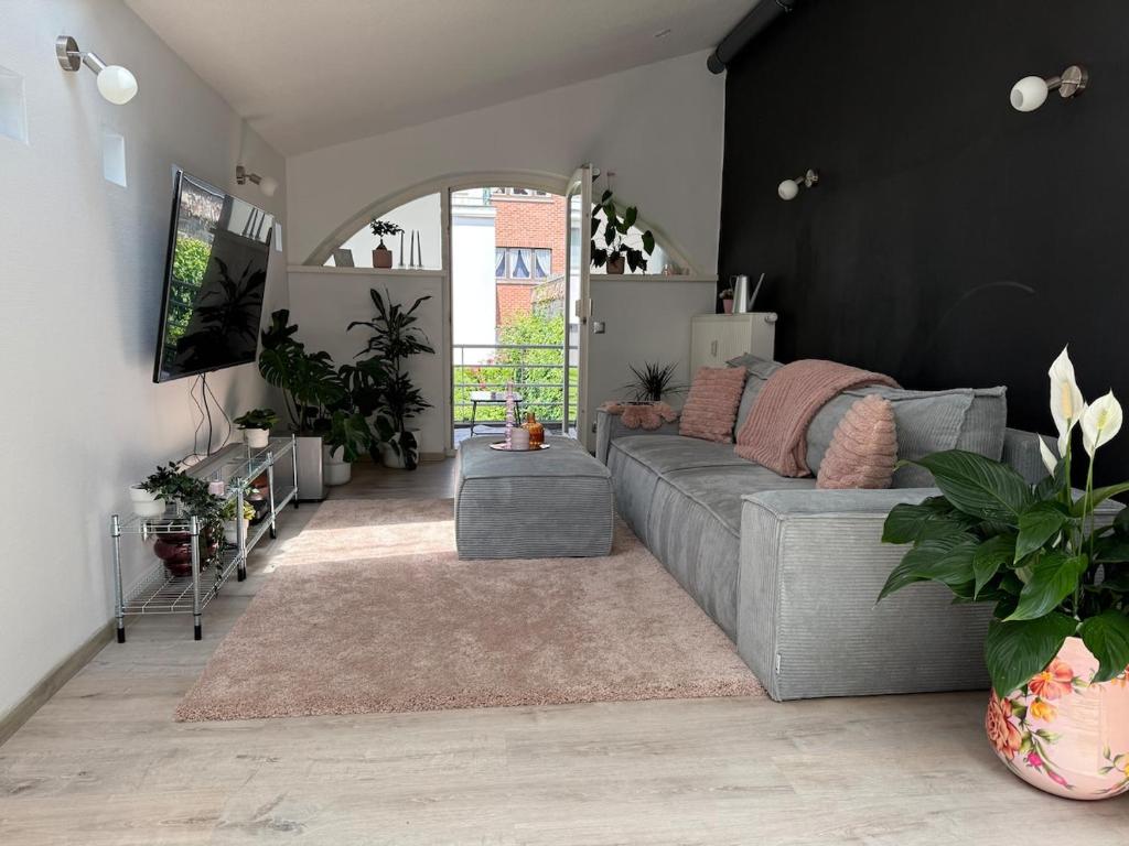 a living room with a gray couch and a black wall at Chez JAJA in Malmedy