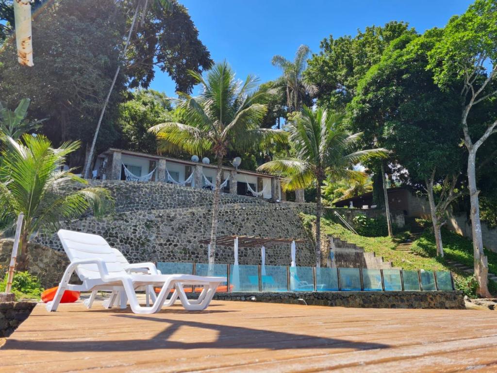 two white chairs and a table in front of a building at Angra dos reis Serra e Mar in Angra dos Reis