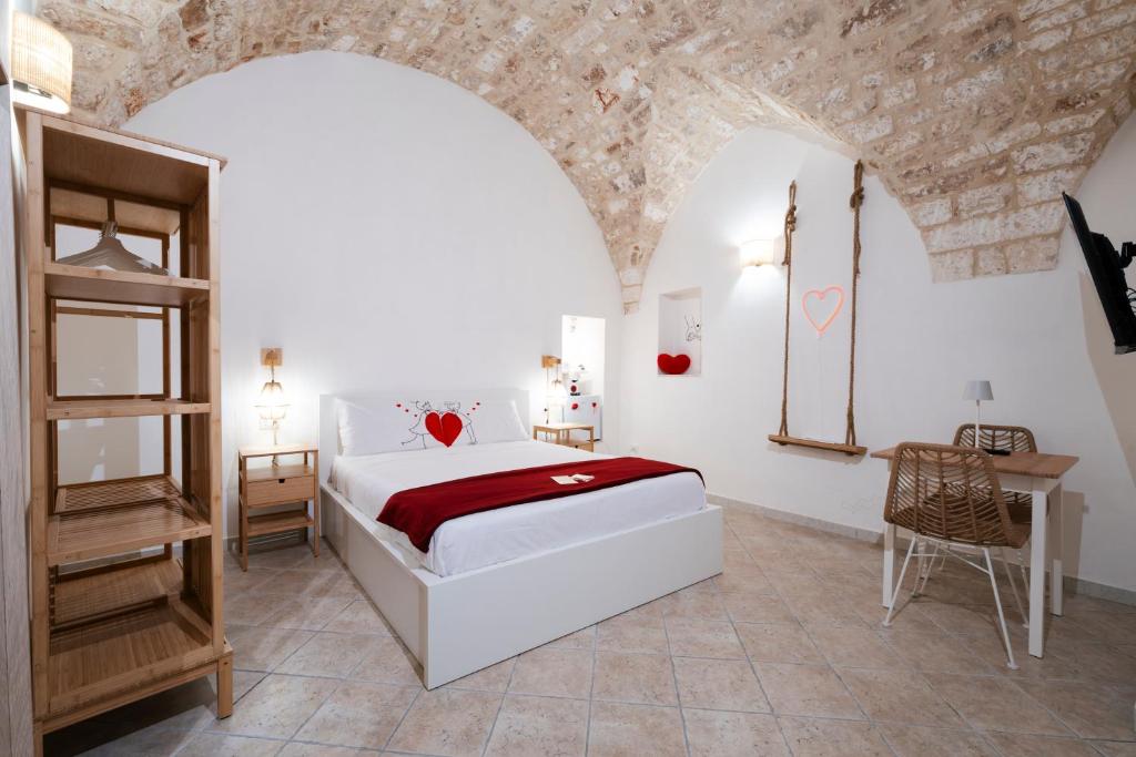 a bedroom with a bed and a table in a room at Filo Rosso in Ostuni