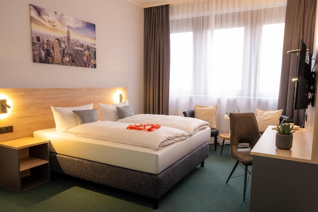 a hotel room with a bed with flowers on it at Best Western Comfort Business Hotel Düsseldorf-Neuss in Neuss