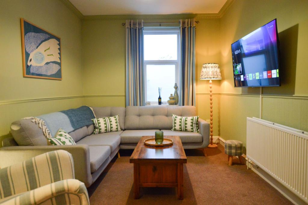 a living room with a couch and a tv at Dunmore Argyll House in Dunoon