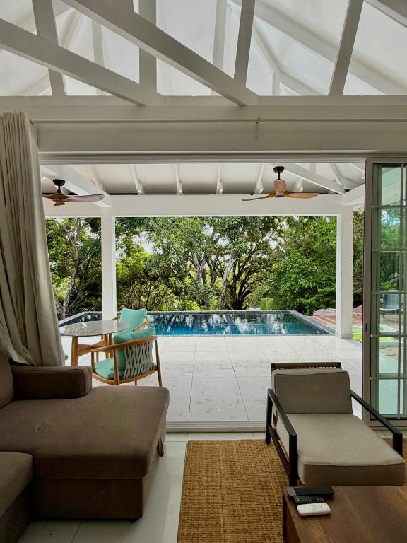 a living room with a view of a swimming pool at Tabu in La Digue