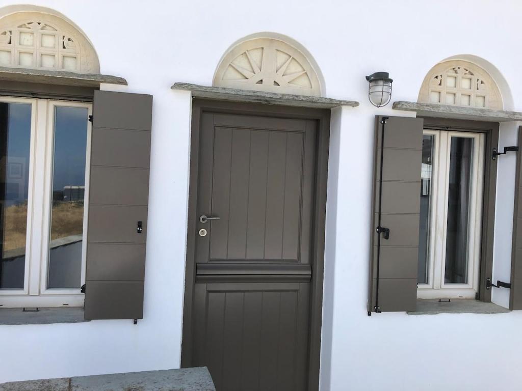 a black door on a white building with windows at To Diko Mas House in Stení
