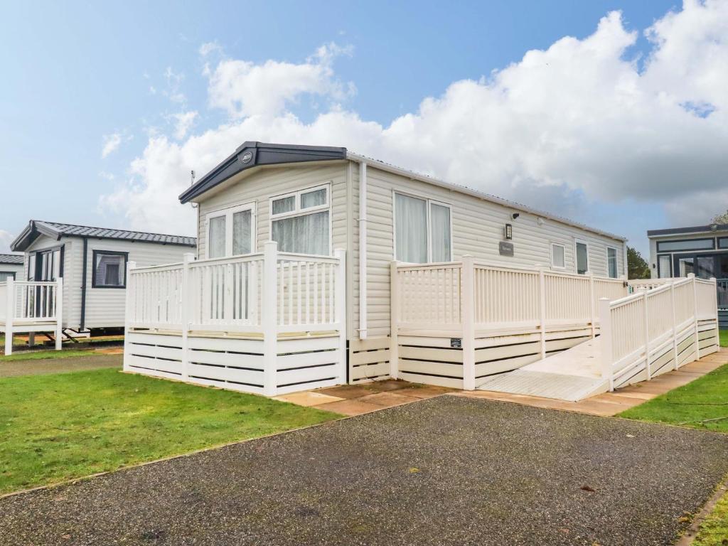 a mobile home with a white fence in a yard at Coastal Escape in Par