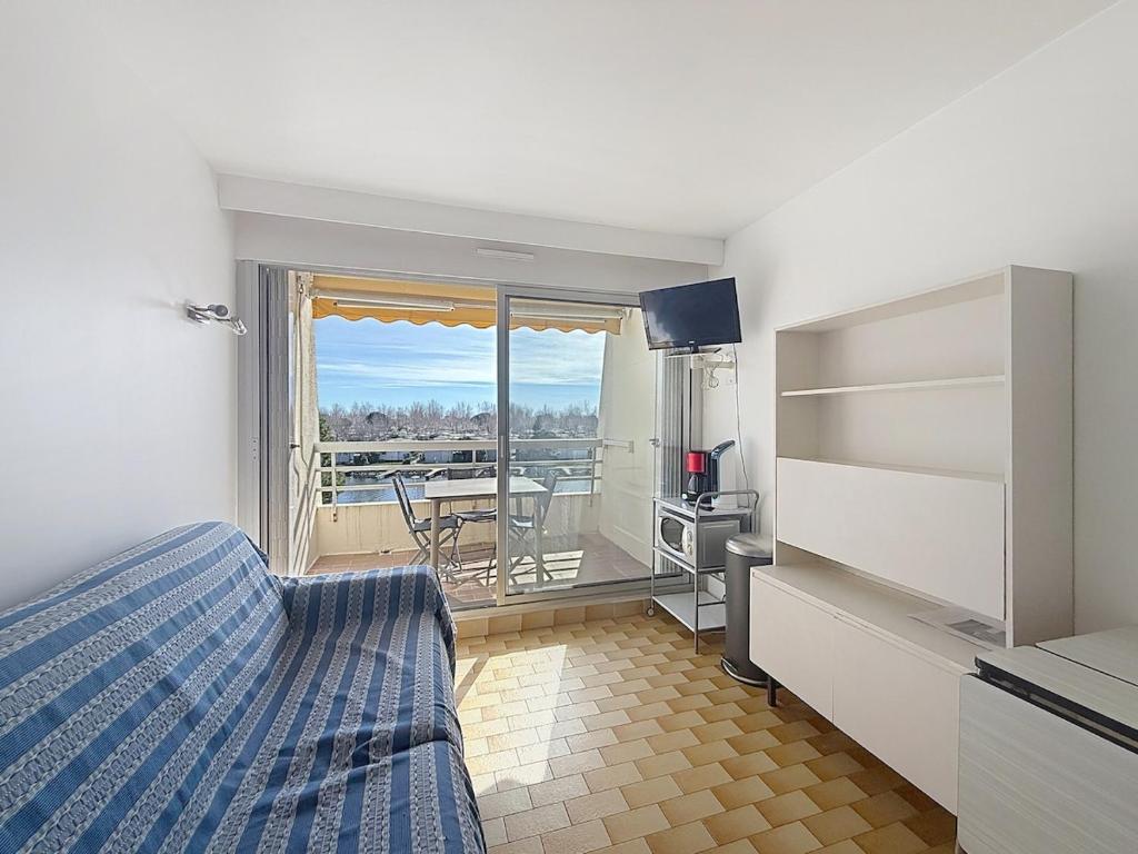 a bedroom with a bed and a view of a balcony at Studio 4 pers La Lagune in Le Grau-du-Roi