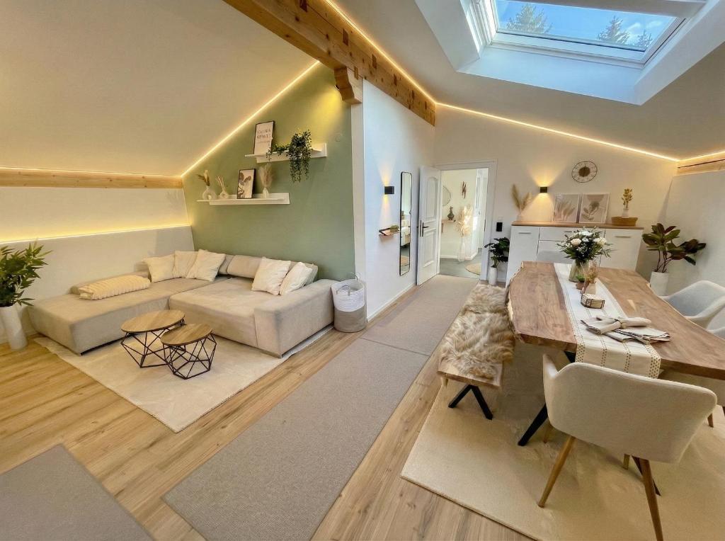 a living room with a couch and a table at Scandinavian Alpine Lodge nahe Tegernsee - stilvoll & ruhig in Reichersbeuern