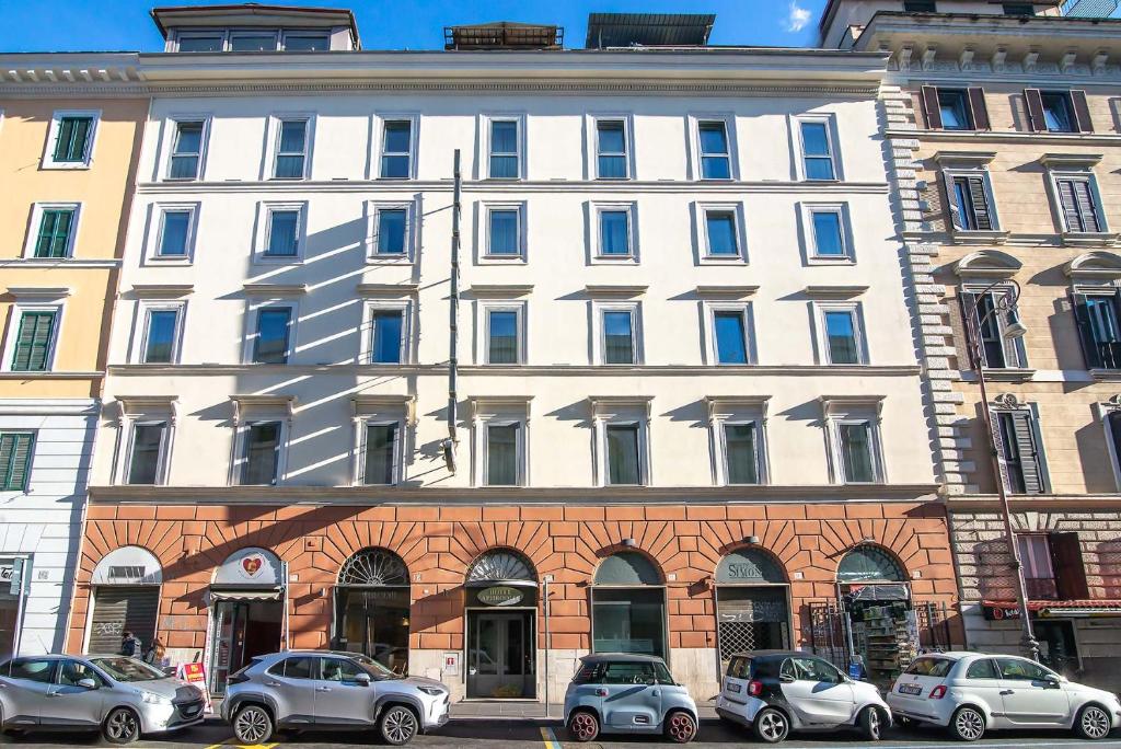 a large white building with cars parked in front of it at Hotel Aphrodite in Rome
