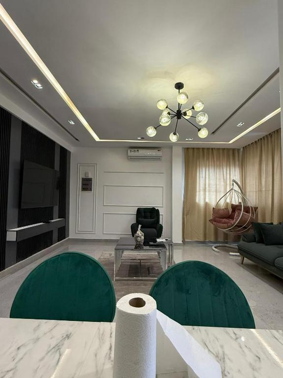 a living room with green chairs and a ceiling at Houefa home résidence in Cotonou