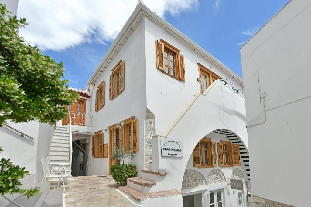 a white house with wooden shuttered windows at Psaropoula Guest House in Hydra