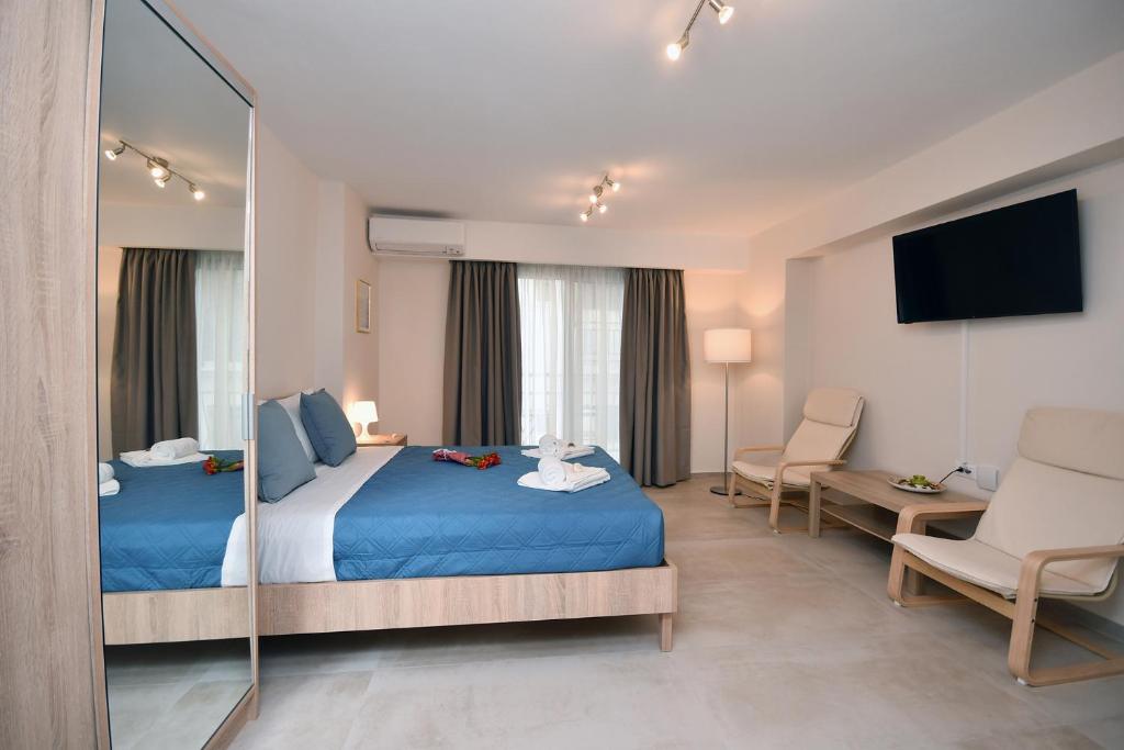 a hotel room with two beds and a mirror at Pietra Sole Residences in Ierapetra
