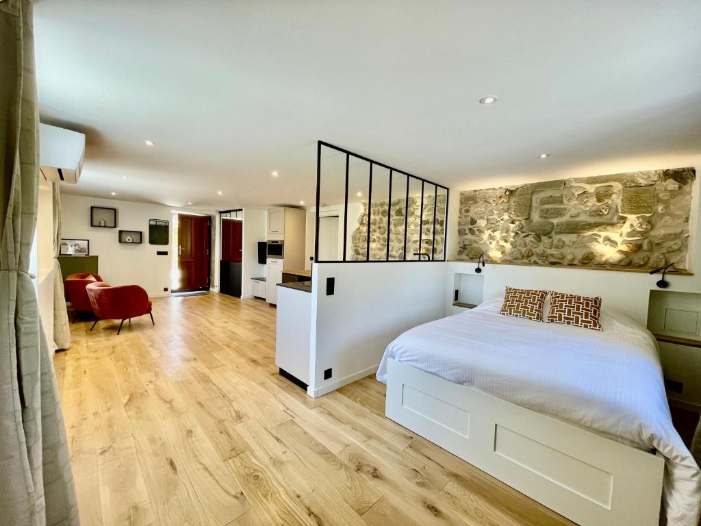 a bedroom with a white bed and a red chair at Mont Pellat - Spacieux studio au Charme Unique in Bassens