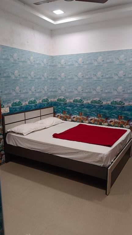 a bedroom with a bed with a painting on the wall at Rk cottage in Rāmeswaram