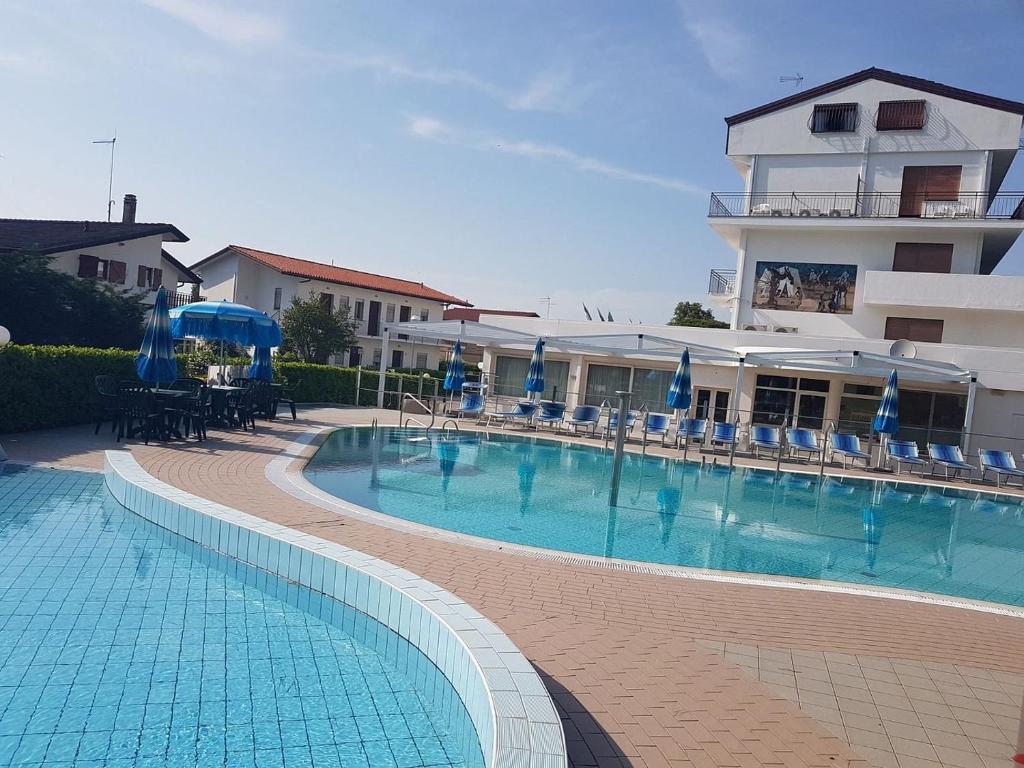 a large swimming pool in front of a building at Hotel Oasi Verde in Lido di Jesolo