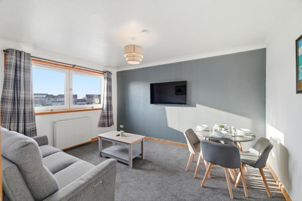 a living room with a couch and a table at Harbour Views in Ferryden