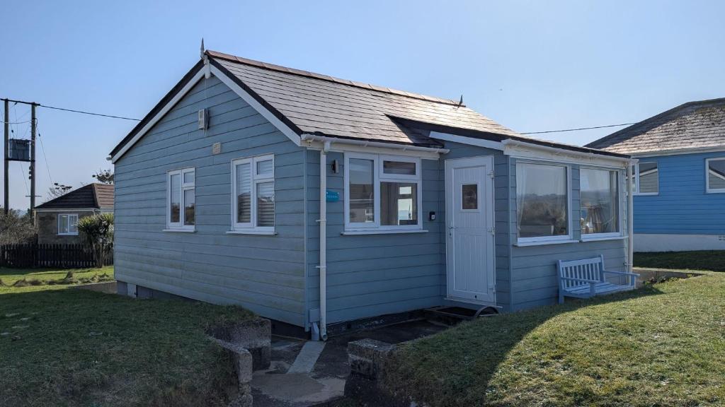 a small blue house with a porch on a yard at C29 Regwin, Riviere Towans in Hayle