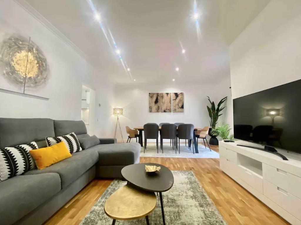 a living room with a gray couch and a table at Central Urban Elegance in Barcelona