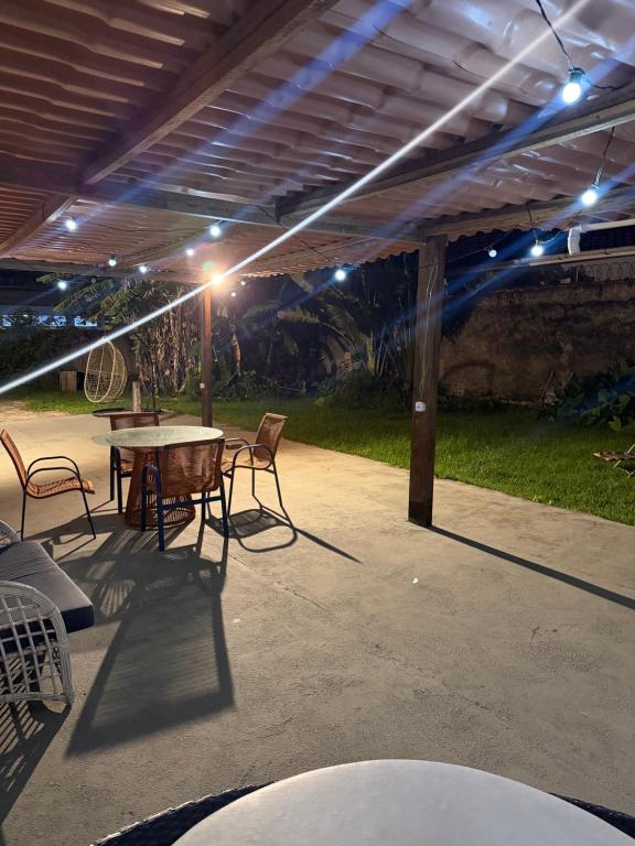 a patio with a table and chairs and lights at Mini Casa Privativa -Praia do Tombo in Guarujá