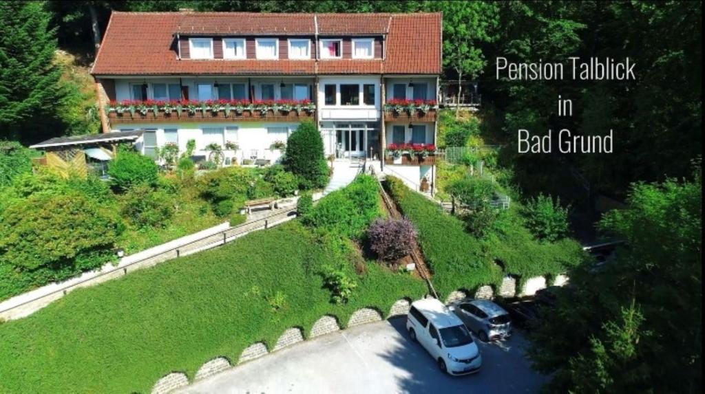 a house with two cars parked in front of it at Pension Talblick Bad Grund in Bad Grund