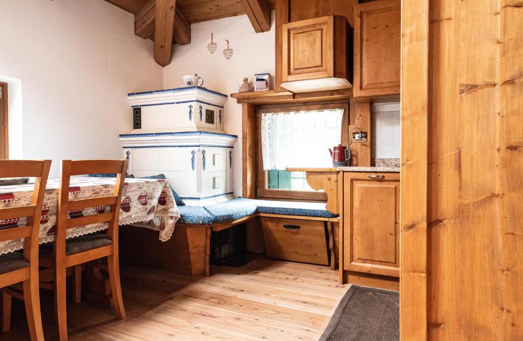 a kitchen with a table and a stove in it at Accogliente mansarda con vista Dolomiti in Borca di Cadore