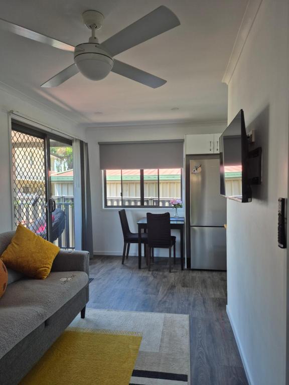 a living room with a couch and a kitchen at Convenient Getaway Home in Strathpine in Strathpine