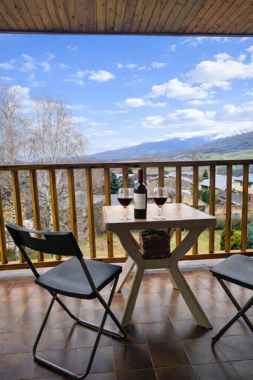 a table with two glasses of wine on a balcony at Llívia Sky Valley in Llivia