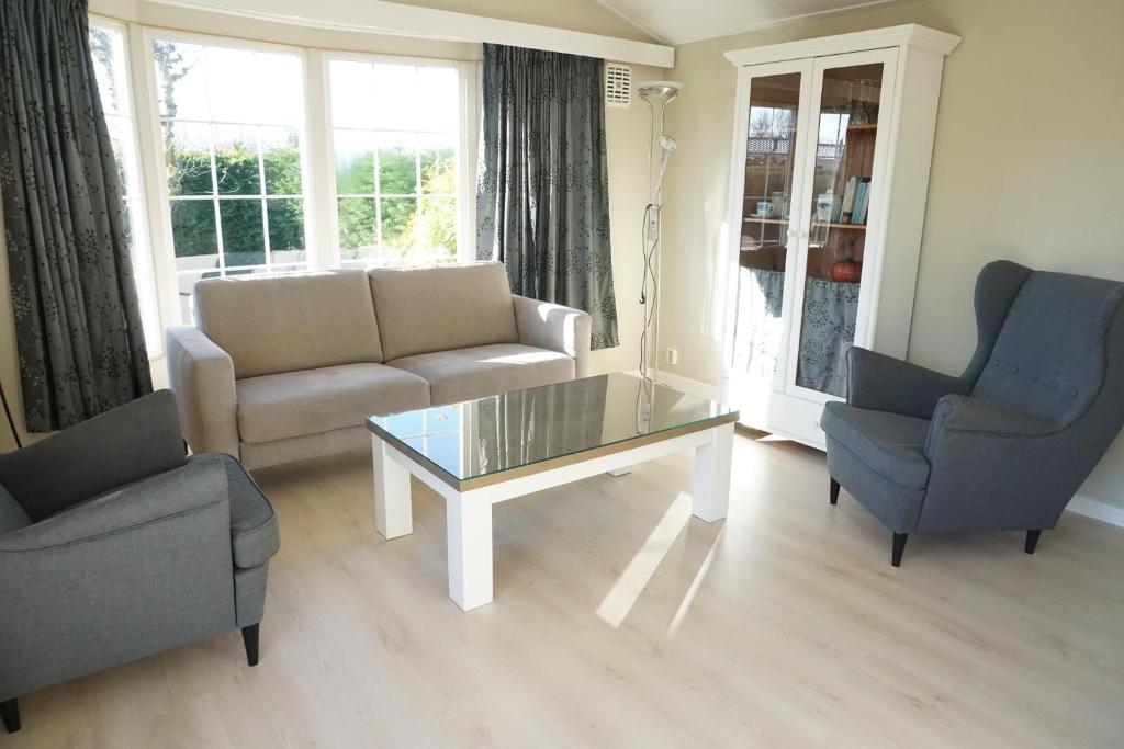 a living room with a couch and a table and chairs at Kustverhuur, Groede, Paarlhof 37 in Groede