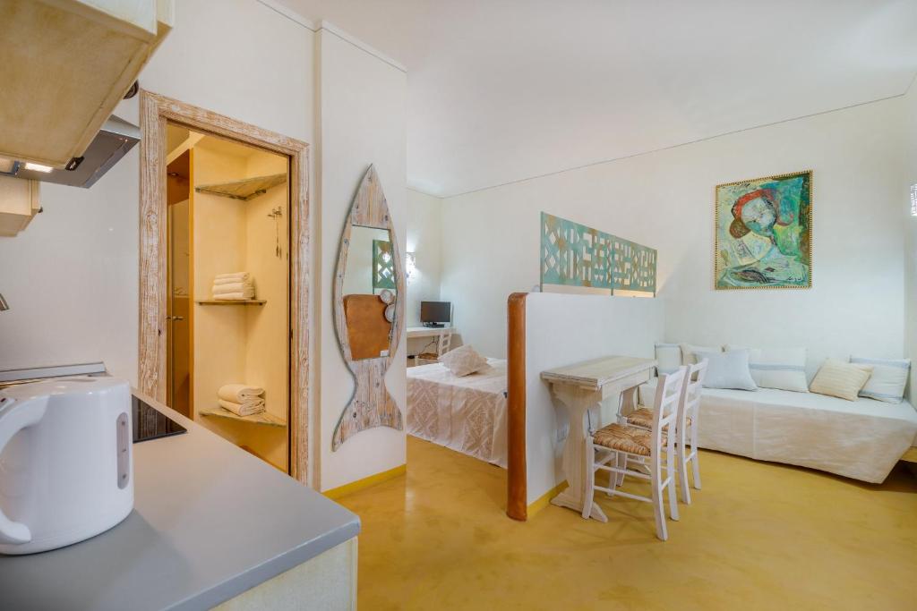 a kitchen and living room with a table and a bed at palazzo beddoro charming apartments in San Pantaleo