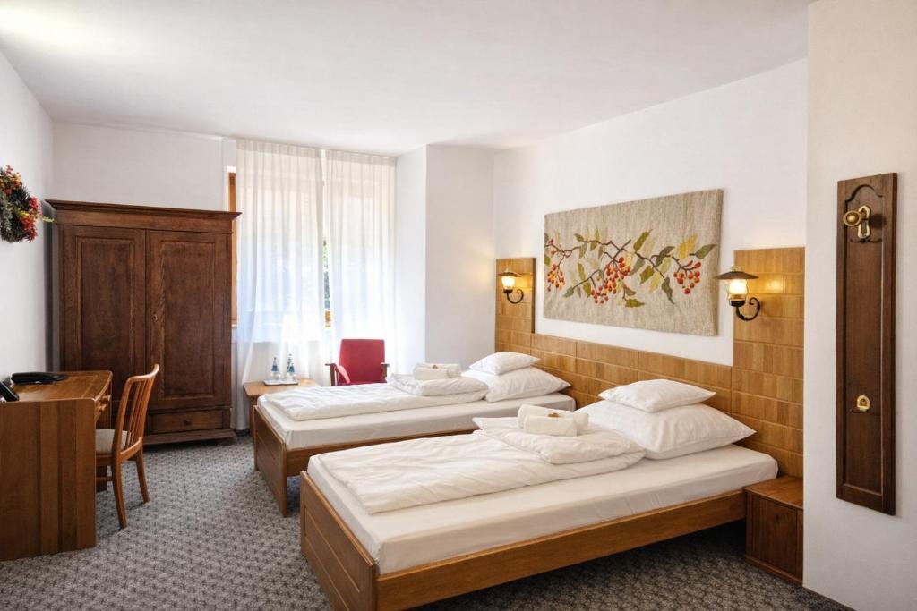 a hotel room with three beds and a table at Hotel Protea Bolesławiec in Bolesławiec