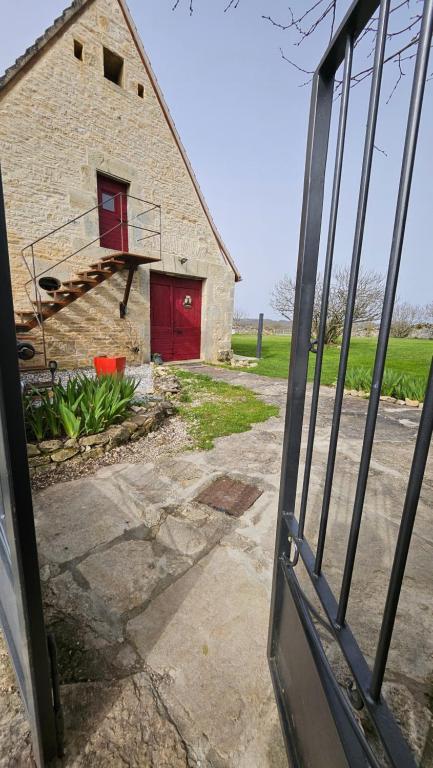 an open door to a brick building with a red garage at L'écurie du Mas in Lamothe-Cassel