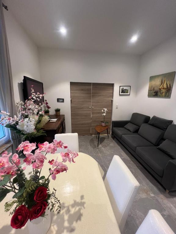 appartement nice في نيس: غرفة معيشة بها أريكة وطاولة عليها زهور