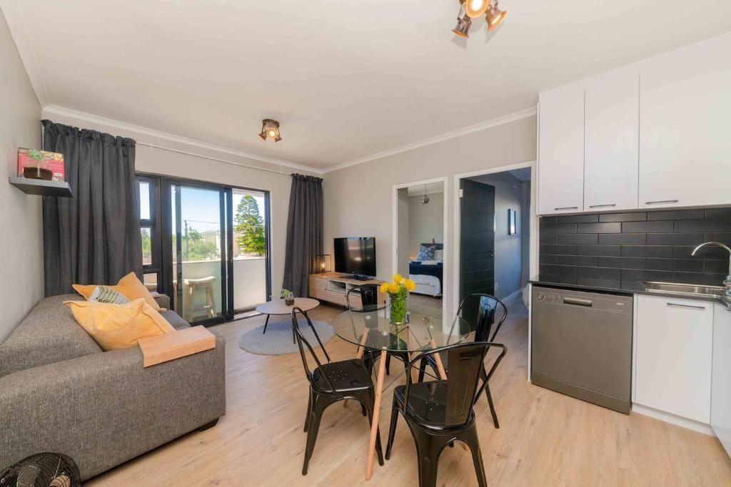 a living room with a couch and a table at Cape on Porterfield in Cape Town