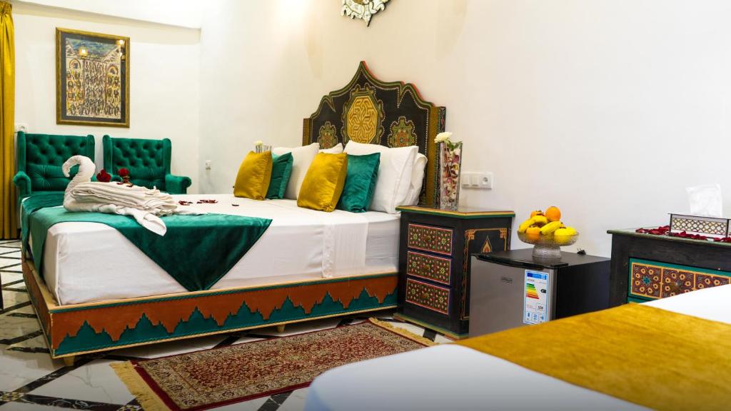 a bedroom with a bed with green and yellow pillows at Riad Lala Zehra in Fez