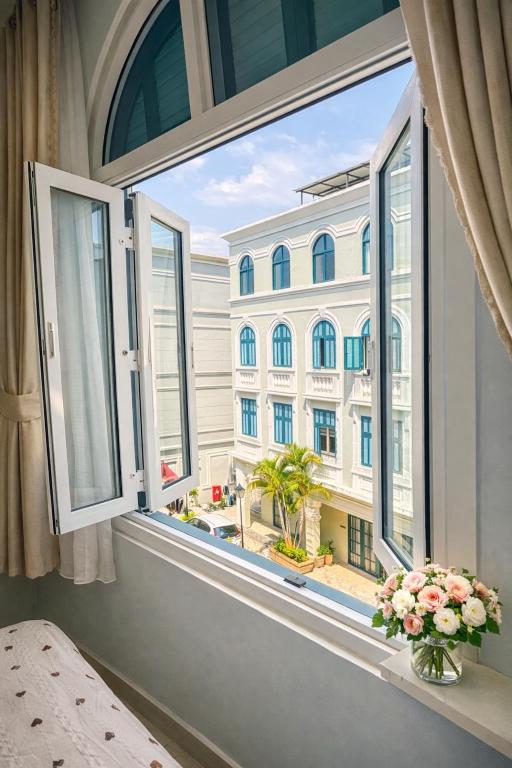 a window with a view of a building at Leo'J Hotel & Apartment in Phú Quốc