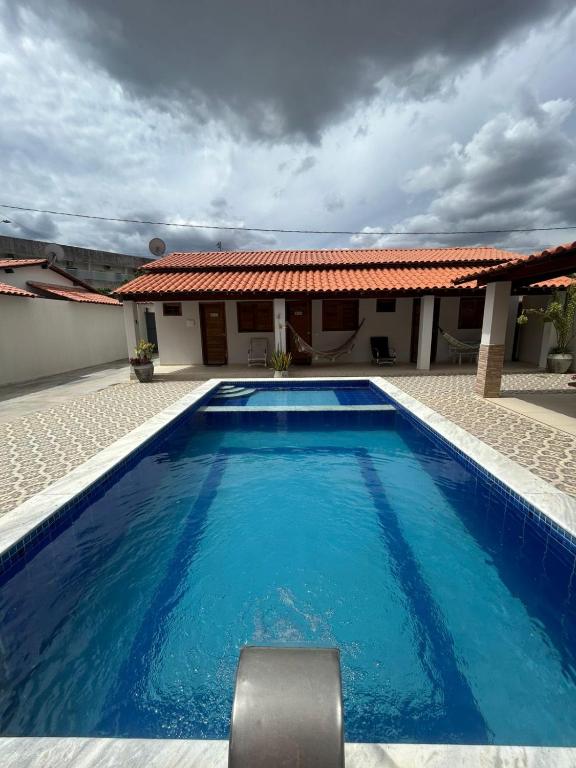 a large blue swimming pool in front of a house at Recanto da Lapinha in Piranhas