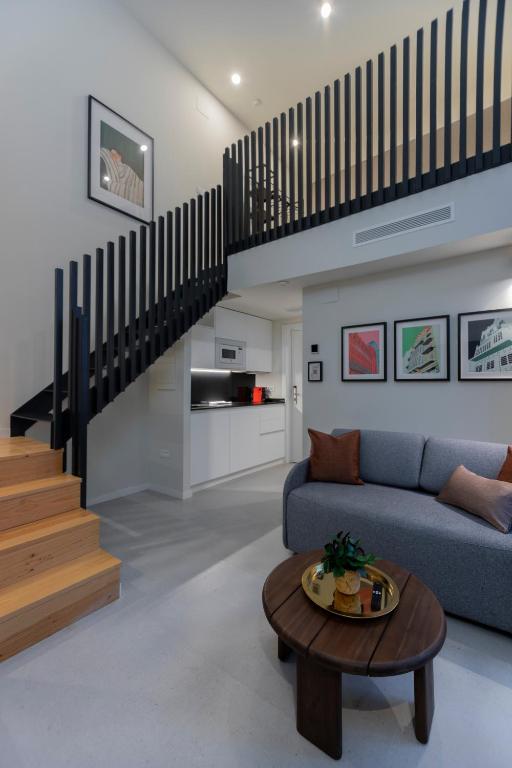 a living room with a blue couch and a staircase at ARENA byAstiblanco in Valencia