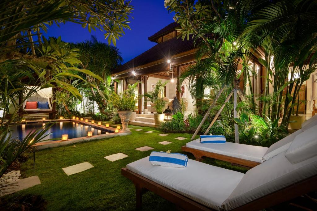a backyard with a swing and a swimming pool at Villa Istana 1 in Seminyak