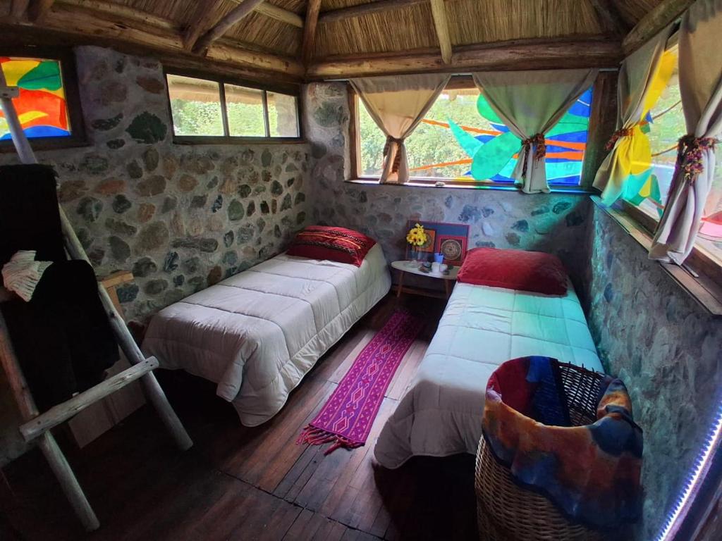 a bedroom with two beds in a room with windows at B&B Dormis de montaña Memé in Potrerillos
