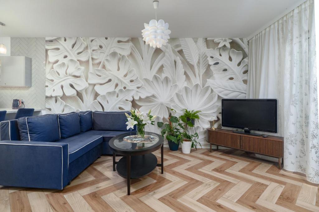 a living room with a blue couch and a tv at Cozy Attic in Marki