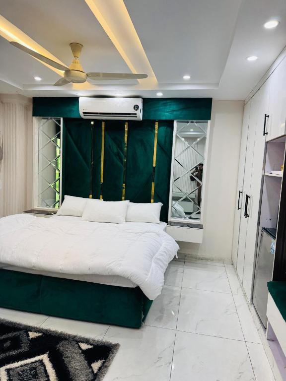 a bedroom with a bed with a green wall at Regency Crown Hotel in Faisalabad