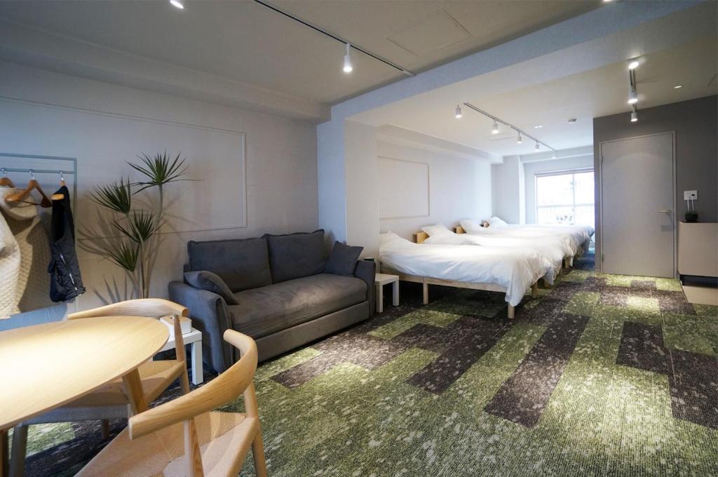 a room with two beds and a couch and a bed at Hotel Sakura Riverside in Nagoya