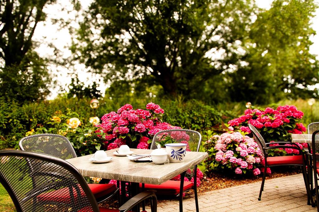 a table and chairs with flowers in a garden at Pension Seeluft in Ahrenshoop