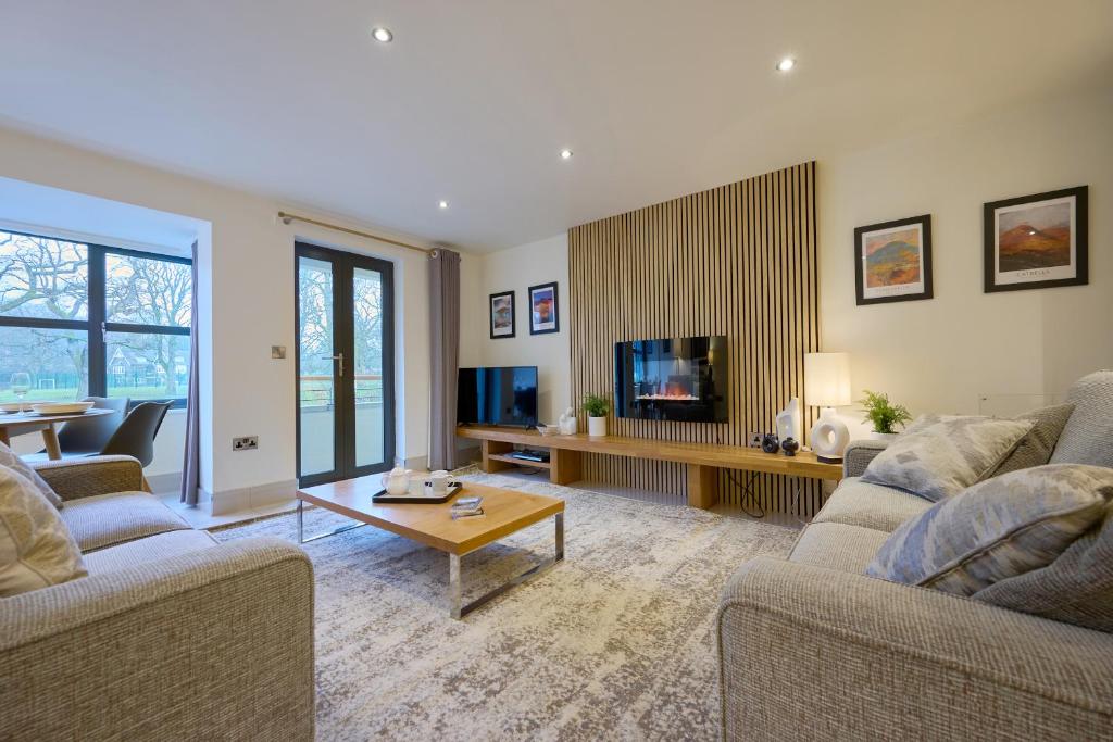 a living room with two couches and a tv at Riverside Park 1 in Keswick