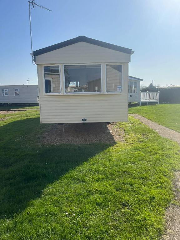 a tiny house sitting on top of a grass field at 159 Summerfields in Great Yarmouth