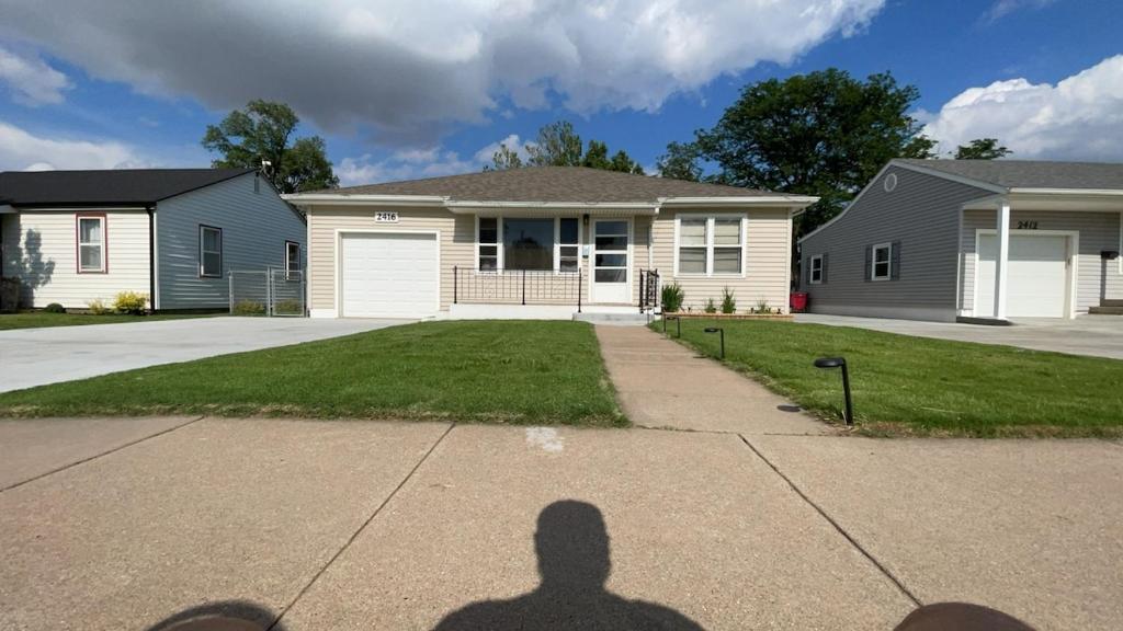 a shadow of a person in front of a house at Gano Street Retreat in Great Bend